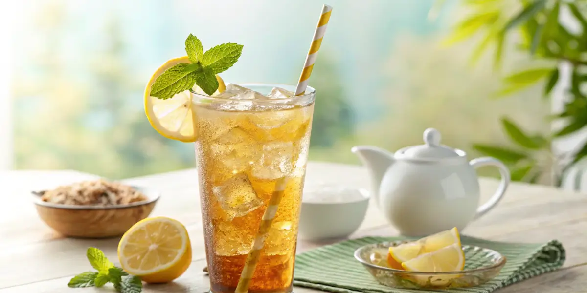 "Refreshing Arnold Palmer drink with iced tea and lemonade served with lemon slices and mint.